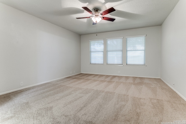 carpeted spare room with a textured ceiling and ceiling fan