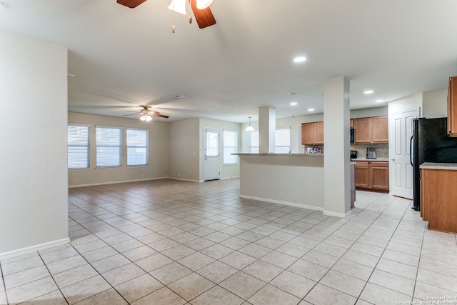 interior space with black appliances, ceiling fan, decorative backsplash, and light tile patterned floors