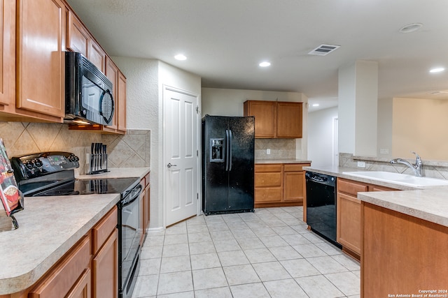 kitchen with decorative backsplash, light tile patterned floors, sink, and black appliances