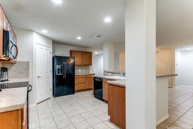 kitchen featuring black appliances, light tile patterned floors, sink, and tasteful backsplash