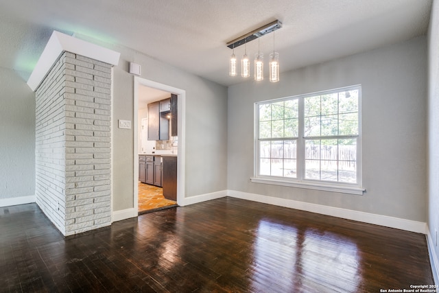 interior space with a textured ceiling, hardwood / wood-style flooring, and a notable chandelier