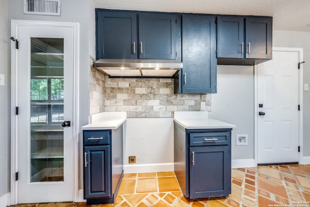 kitchen with a textured ceiling, backsplash, and blue cabinets