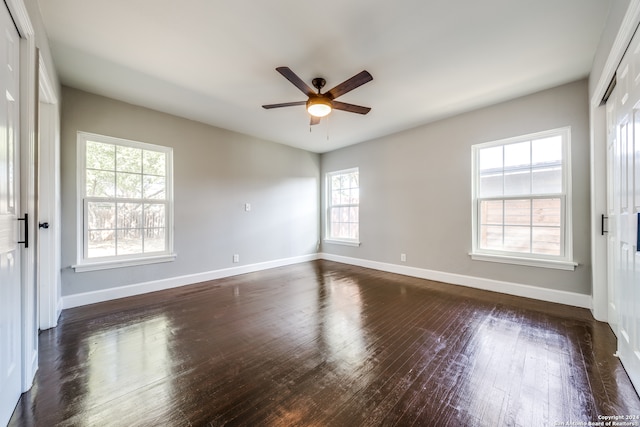 empty room with ceiling fan and dark wood-type flooring