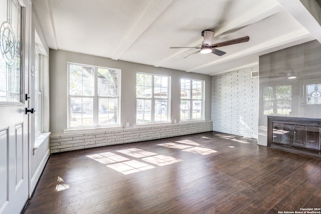 unfurnished sunroom featuring ceiling fan and beamed ceiling