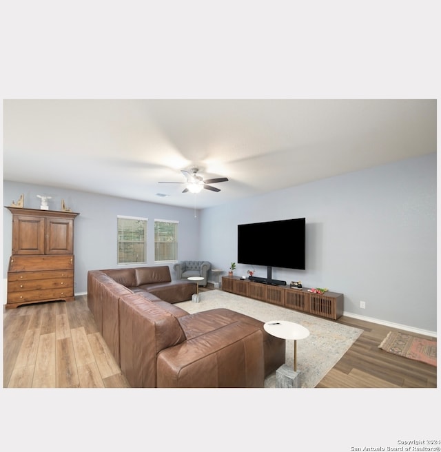 living room featuring ceiling fan and light hardwood / wood-style flooring