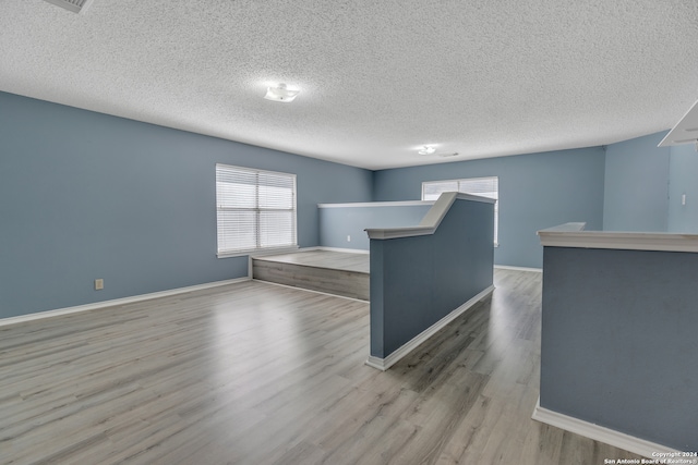 unfurnished room featuring a textured ceiling and light hardwood / wood-style floors