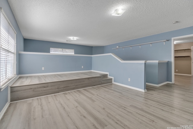 spare room featuring light hardwood / wood-style floors and a textured ceiling