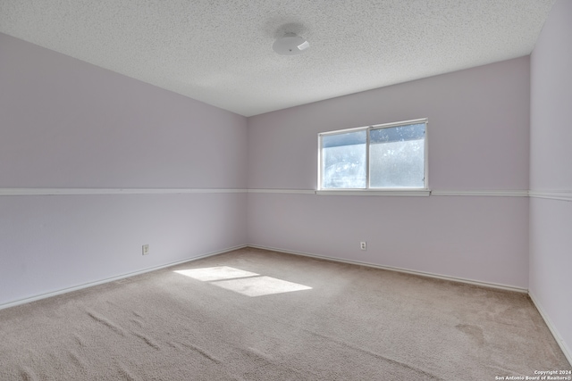 carpeted empty room featuring a textured ceiling