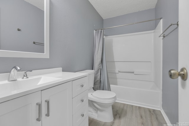 full bathroom featuring vanity, shower / bath combination with curtain, hardwood / wood-style flooring, toilet, and a textured ceiling