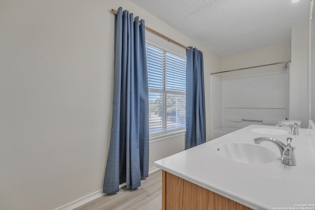 bathroom with hardwood / wood-style floors, vanity, and a textured ceiling