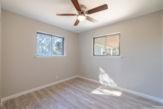 empty room featuring plenty of natural light, ceiling fan, and light hardwood / wood-style flooring