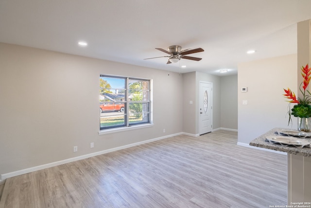 unfurnished living room featuring light wood-type flooring and ceiling fan