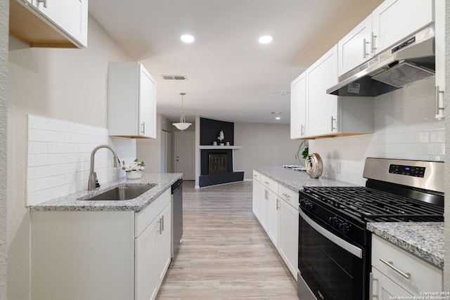 kitchen with hanging light fixtures, sink, light hardwood / wood-style flooring, appliances with stainless steel finishes, and white cabinetry