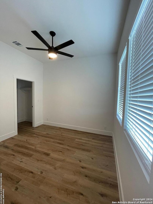 empty room with ceiling fan and dark wood-type flooring