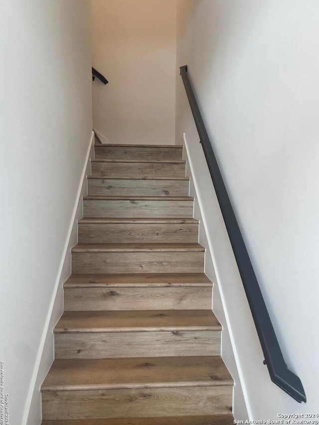 stairs featuring hardwood / wood-style floors