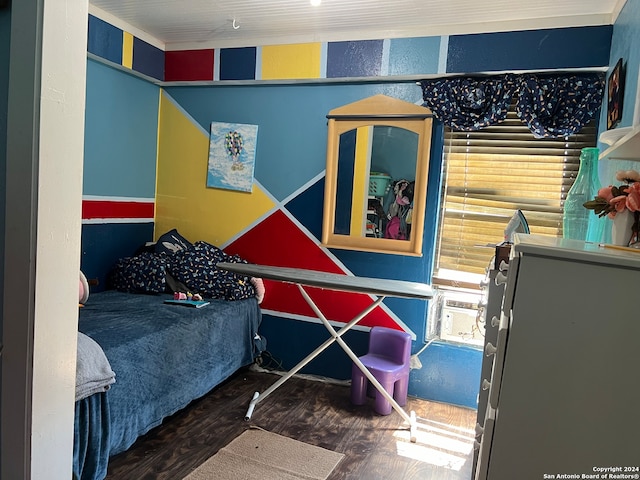 bedroom with wood-type flooring and fridge