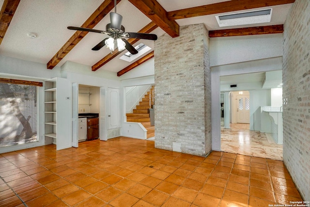 unfurnished living room with ceiling fan, beamed ceiling, high vaulted ceiling, brick wall, and light tile patterned floors