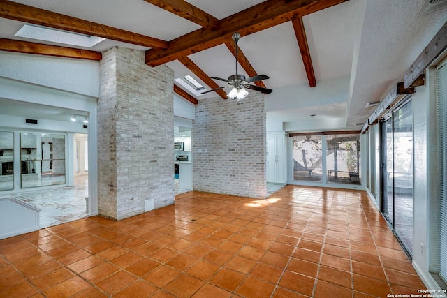 unfurnished living room featuring high vaulted ceiling, ceiling fan, beamed ceiling, light tile patterned flooring, and brick wall