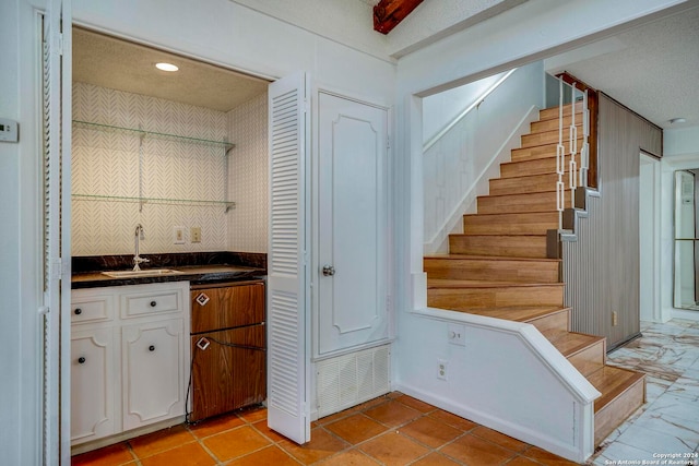 kitchen featuring white cabinetry, sink, and a textured ceiling