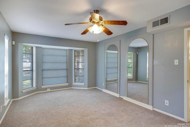 empty room with ceiling fan and light colored carpet