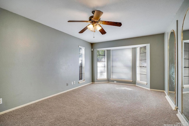 carpeted spare room featuring ceiling fan