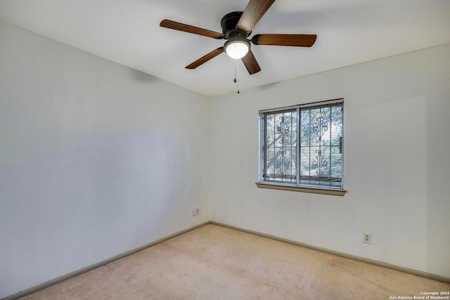 spare room featuring light carpet and ceiling fan