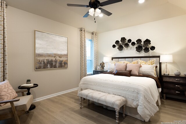 bedroom featuring lofted ceiling, light hardwood / wood-style flooring, and ceiling fan