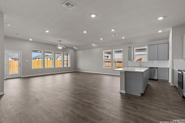 kitchen with tasteful backsplash, stainless steel appliances, gray cabinets, and plenty of natural light