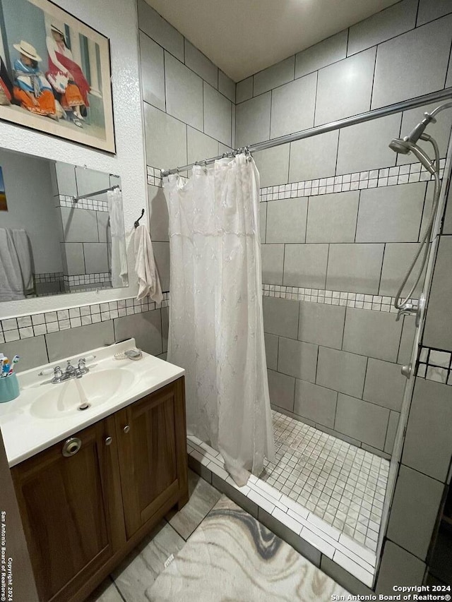 bathroom with backsplash, a shower with curtain, tile patterned flooring, and vanity