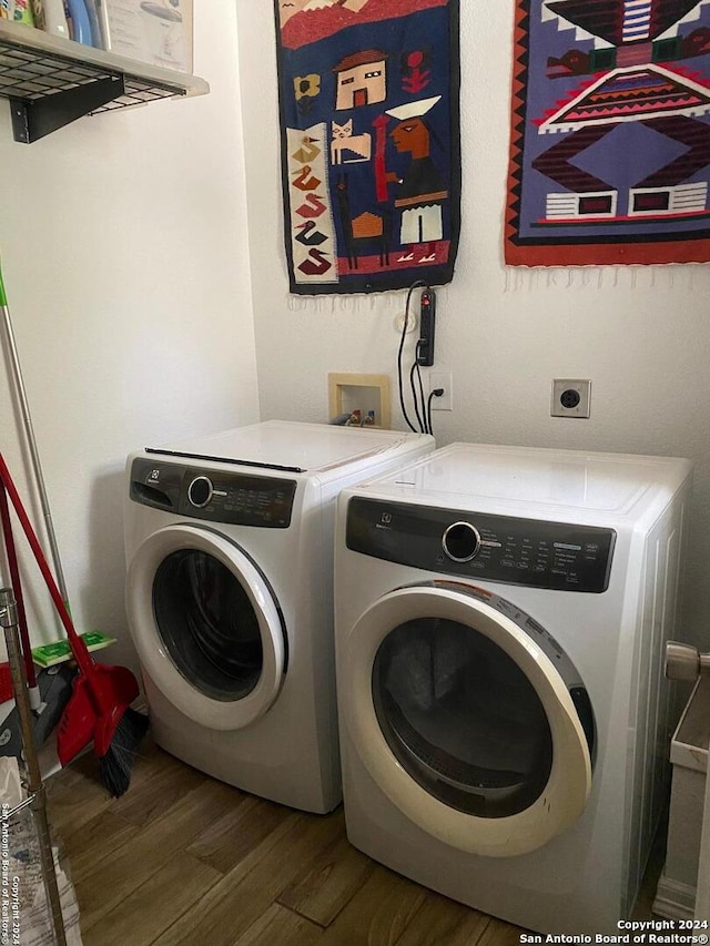 laundry area with separate washer and dryer and dark hardwood / wood-style floors