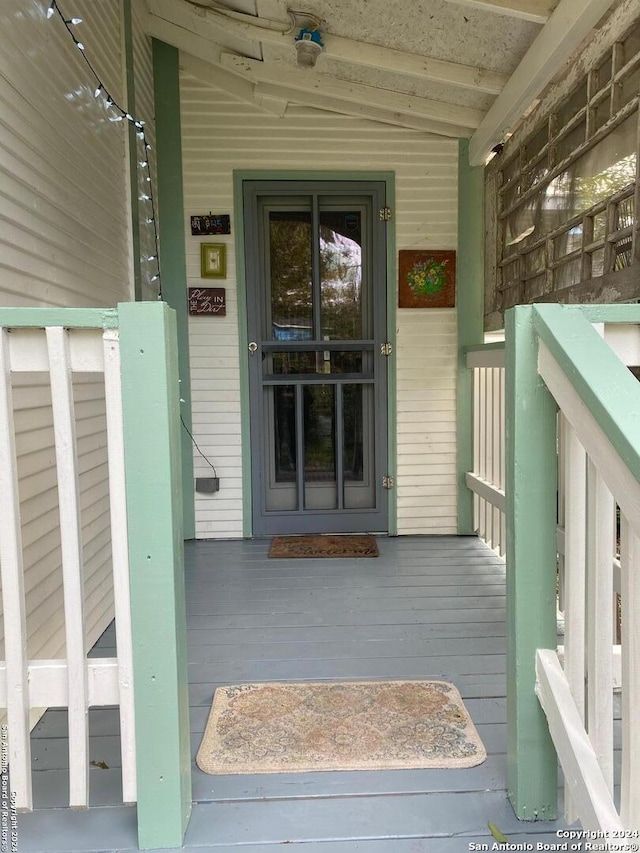 view of exterior entry with a porch