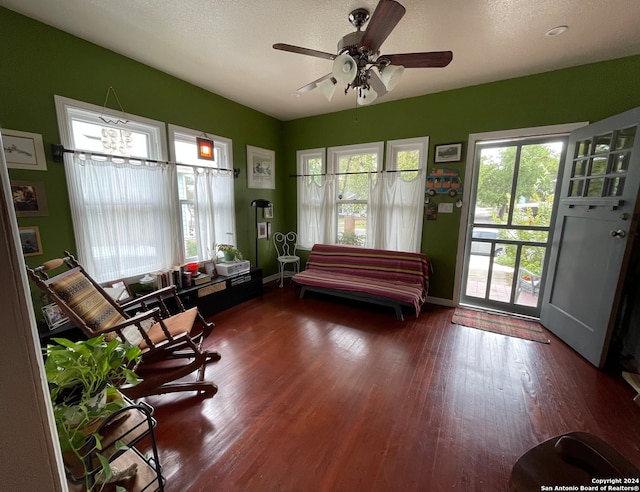 interior space with a textured ceiling, ceiling fan, and dark wood-type flooring