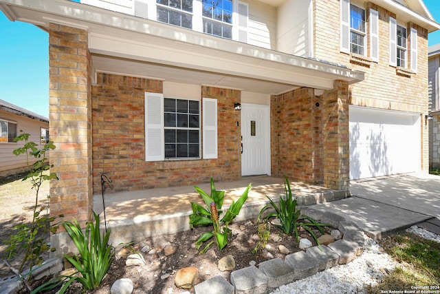 property entrance with covered porch and a garage