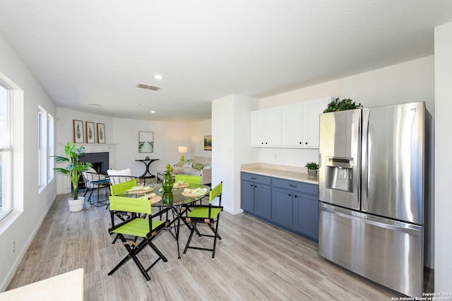 kitchen featuring white cabinetry, light hardwood / wood-style flooring, stainless steel refrigerator with ice dispenser, and blue cabinets