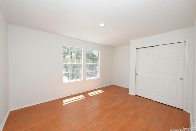 unfurnished bedroom featuring light wood-type flooring and a closet