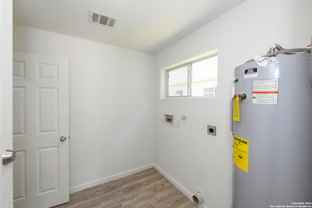 clothes washing area featuring water heater, hookup for an electric dryer, washer hookup, and light wood-type flooring