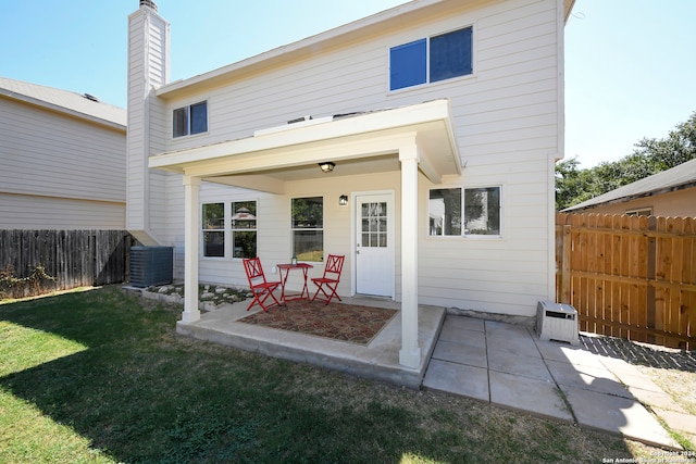 back of property with a lawn, a patio, and central AC unit