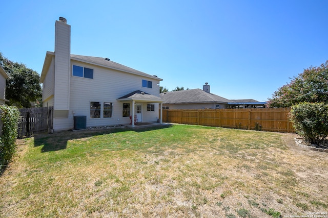 back of house with central air condition unit, a yard, and a patio