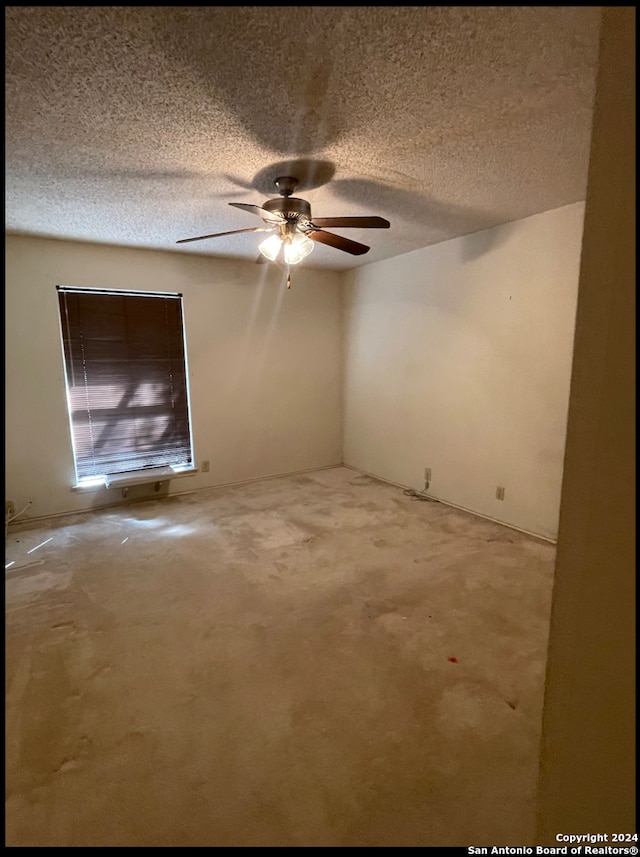 empty room with a textured ceiling and ceiling fan