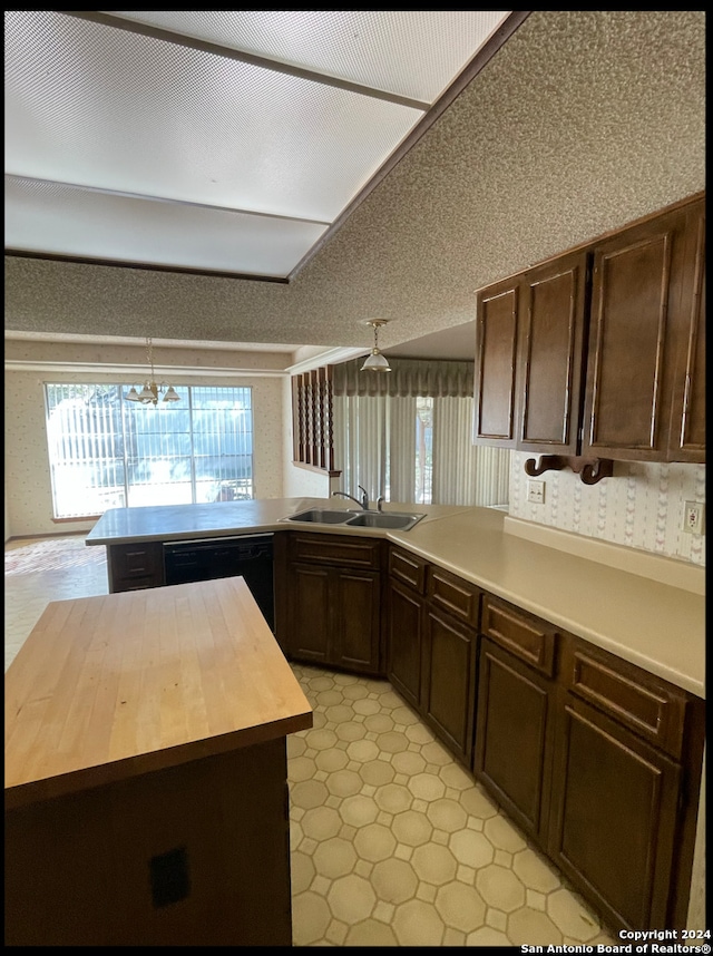 kitchen featuring kitchen peninsula, black dishwasher, butcher block counters, and sink