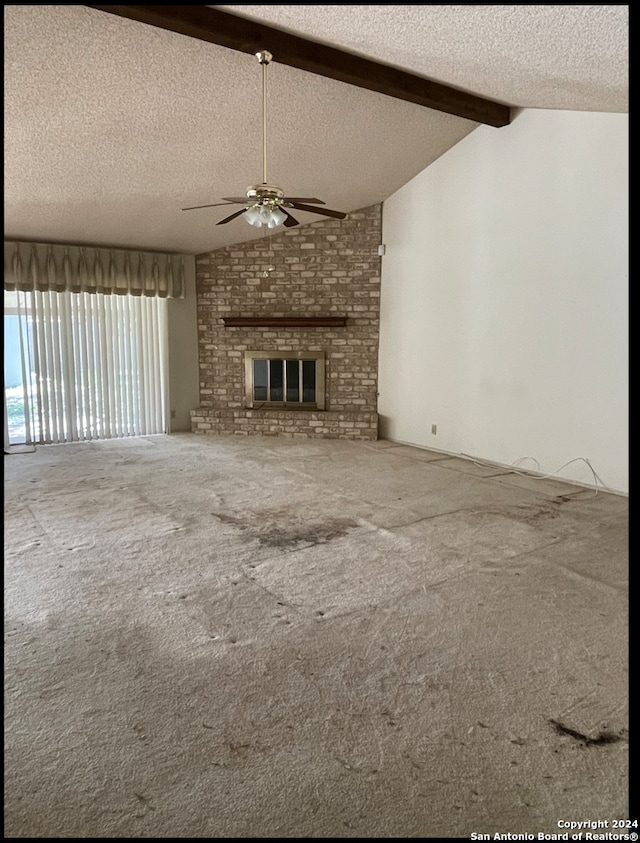 unfurnished living room with carpet flooring, lofted ceiling with beams, a textured ceiling, and a brick fireplace