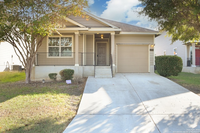 view of front of home with a porch, a garage, and central AC unit