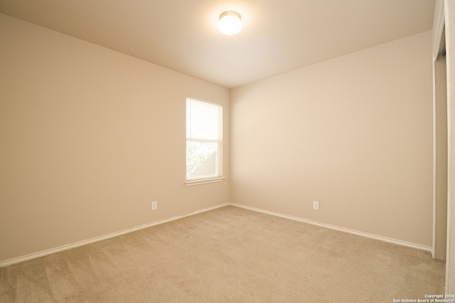 spare room featuring light colored carpet