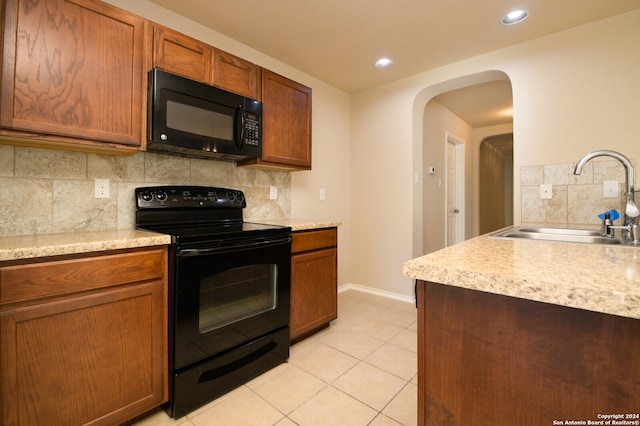 kitchen with light tile patterned flooring, sink, tasteful backsplash, and black appliances