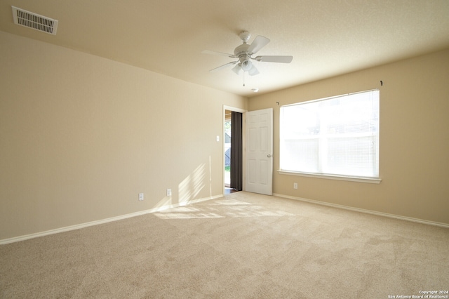 unfurnished room with ceiling fan and light carpet