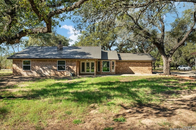 view of front of property featuring a front yard and french doors