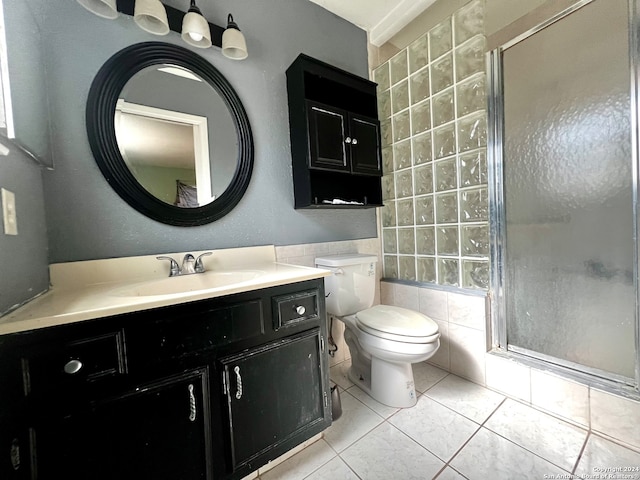 bathroom featuring vanity, tile patterned floors, toilet, tile walls, and walk in shower