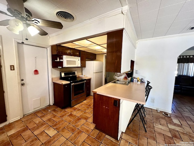 6118 Elm Valley Dr, San Antonio, TX 78242 - kitchen featuring white appliances, ornamental molding, ceiling fan, a kitchen breakfast bar, and light countertops