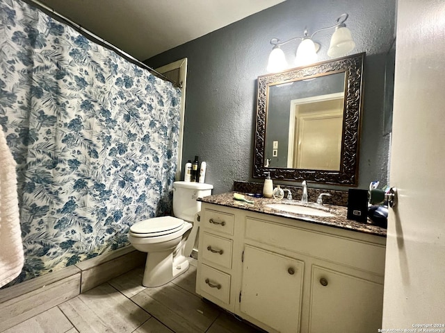 6118 Elm Valley Dr, San Antonio, TX 78242 - full bathroom featuring vanity, toilet, a textured wall, a shower with shower curtain, and wood finished floors
