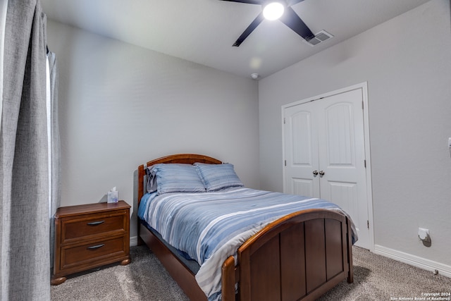 bedroom featuring dark colored carpet, a closet, and ceiling fan